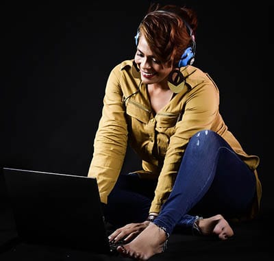 Une femme utilise un logiciel de DJ sur son Macbook.