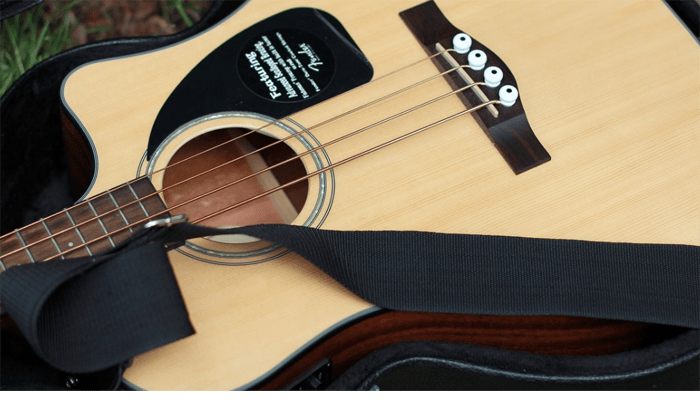 Acoustic guitar on the ground with strap