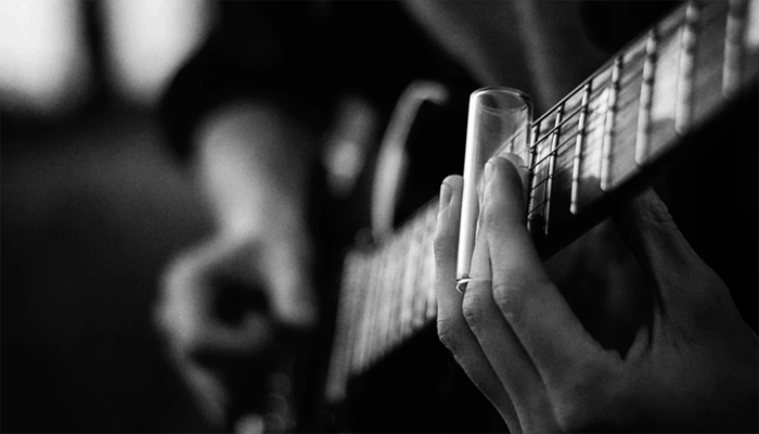 Person playing guitar with guitar slide