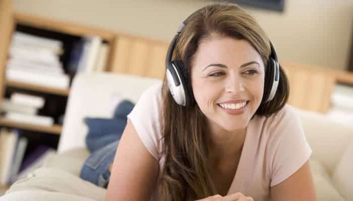 Woman listening to headphones smiling