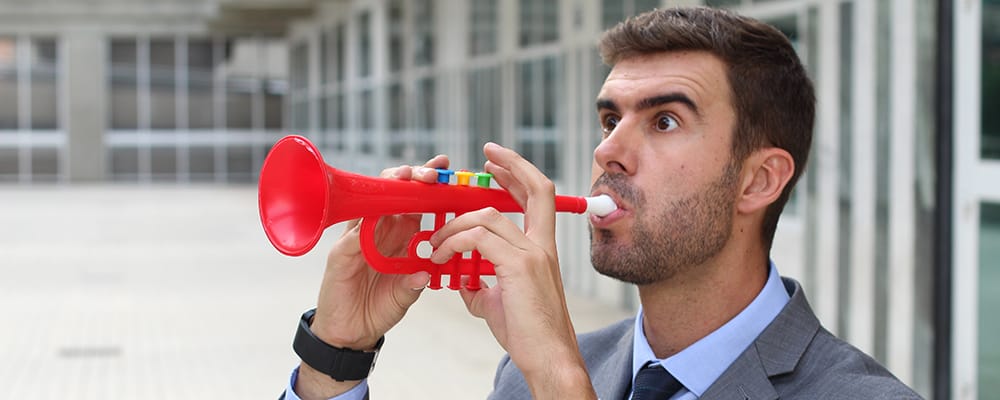 Hombre tocando una trompeta de plástico