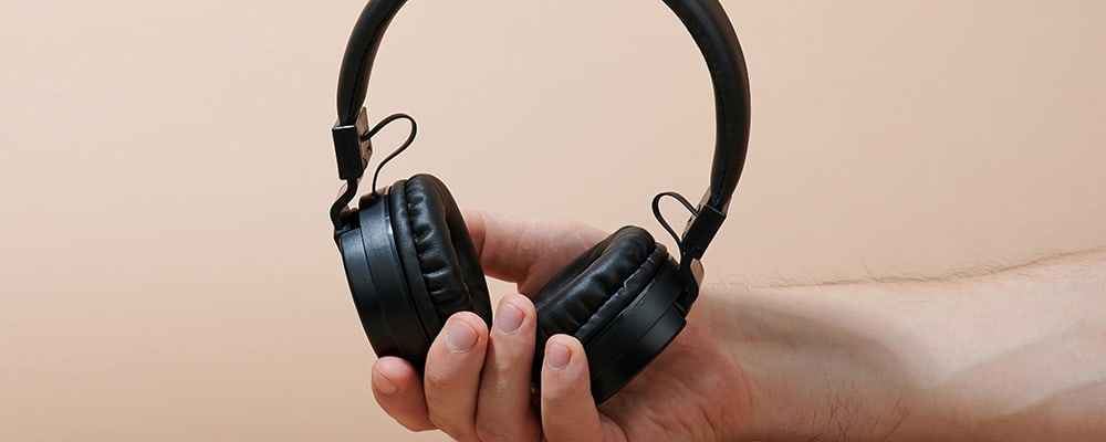 Auriculares inalámbricos en la mano del hombre