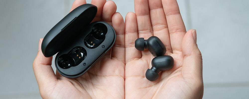 Wireless earbuds on person's hands