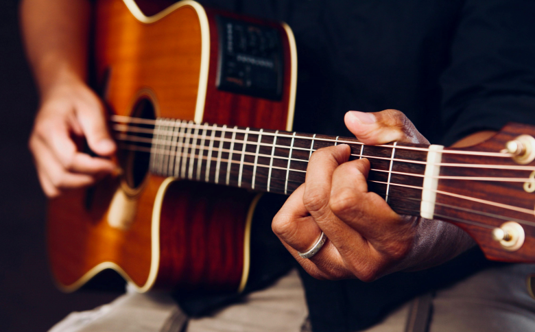 person playing acoustic guitar