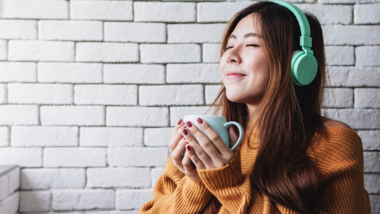 girl enjoying her drink while listening to music