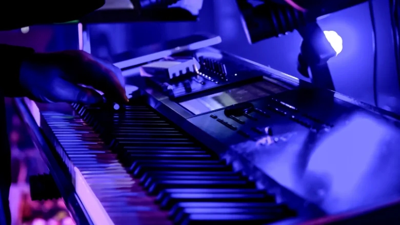 keyboard on stage under purple lights