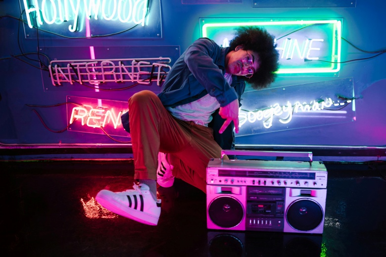 man posing with boombox in neon-lit room