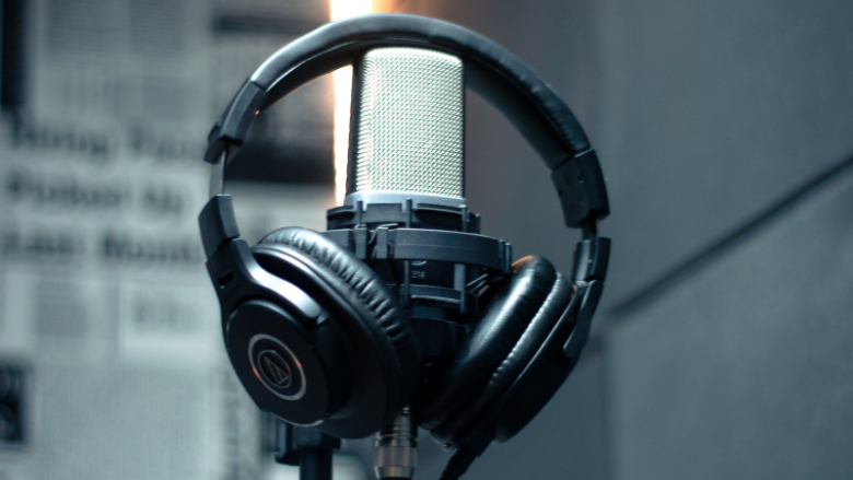 studio microphone with headphones hanging on stand