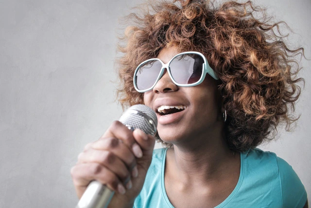 Person using karaoke microphone while singing