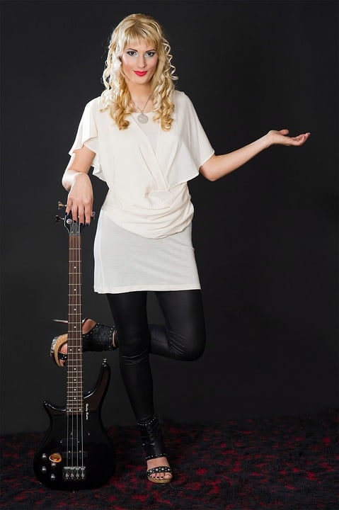 Woman with small hands next to small electric guitar