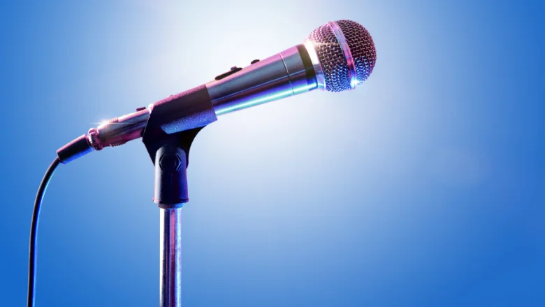 close-up of microphone on a stand with blue background