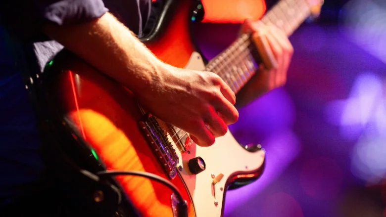 person using electric guitar